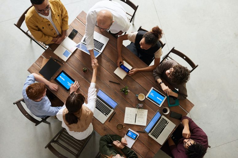 group of people gathers around a table discussing talent acquisition