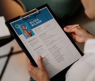 professional person reviewing a resume on a clipboard