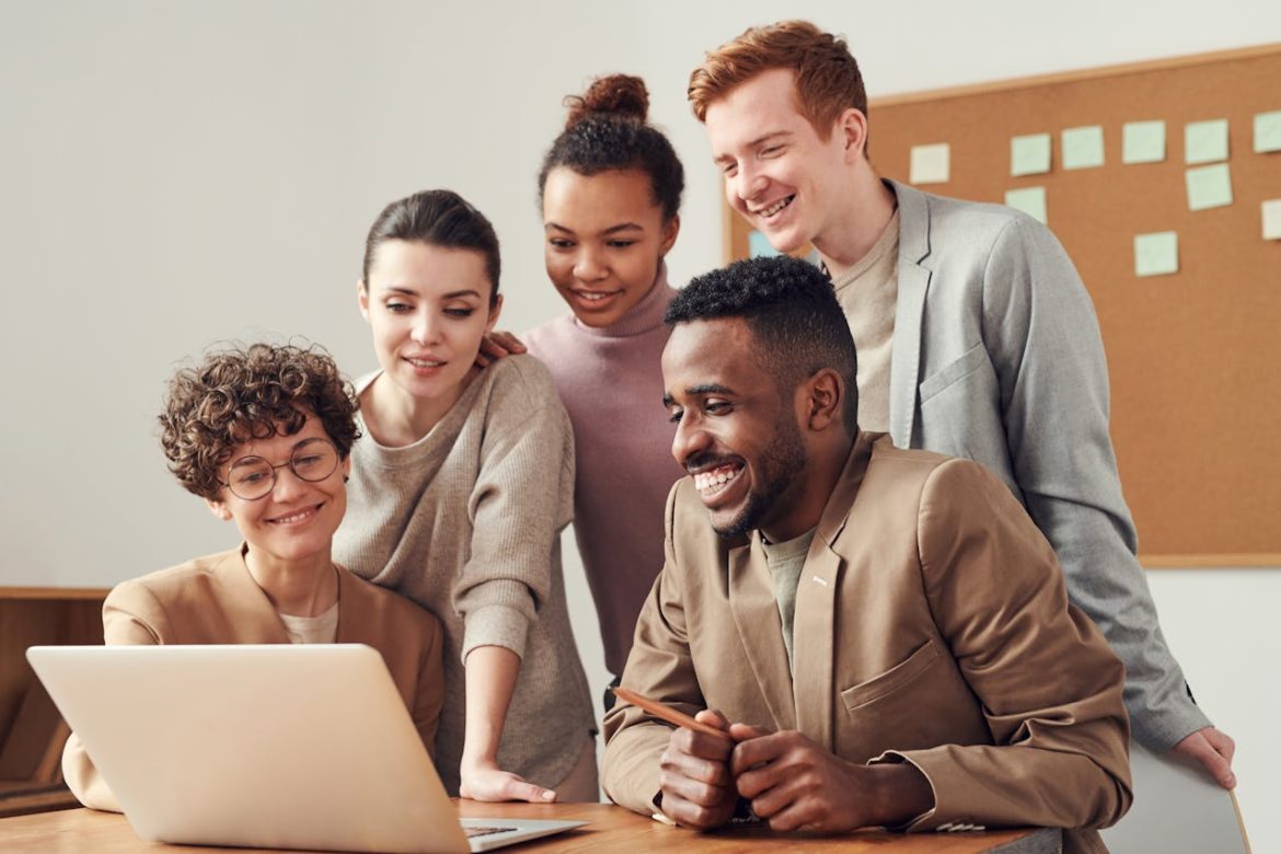 young professionals gathered around a laptop